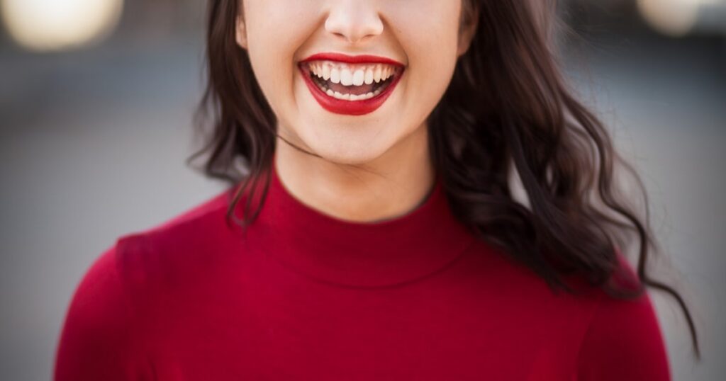 Woman smiling outdoors in sunlight
